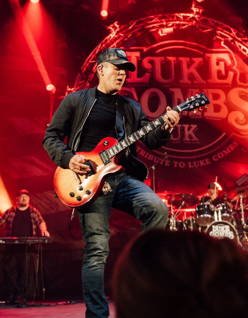 Dan performing live in front of the Luke Combs UK tribute backdrop